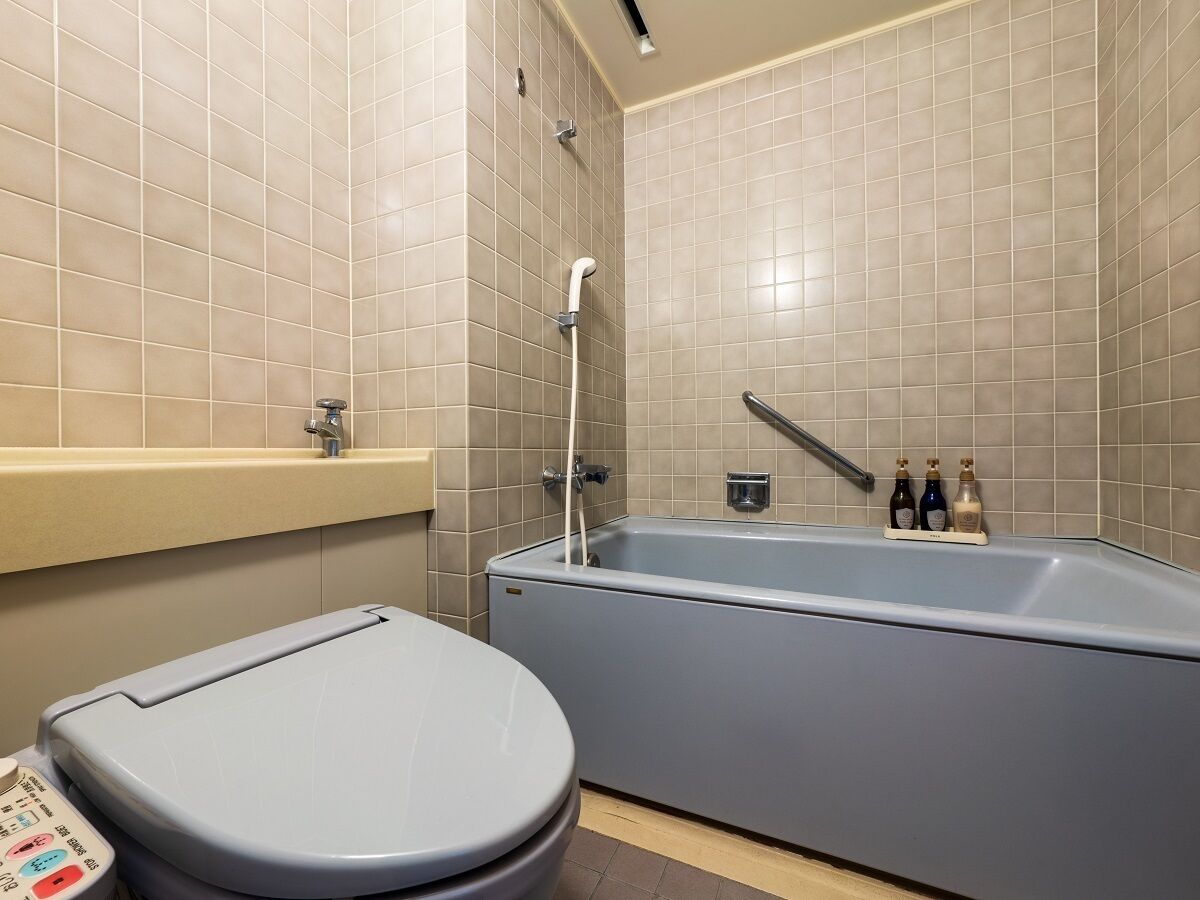 Un baño moderno con bañera, inodoro y panel de control.