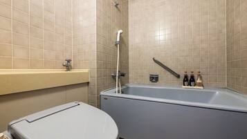 Un baño moderno con bañera, inodoro y panel de control.