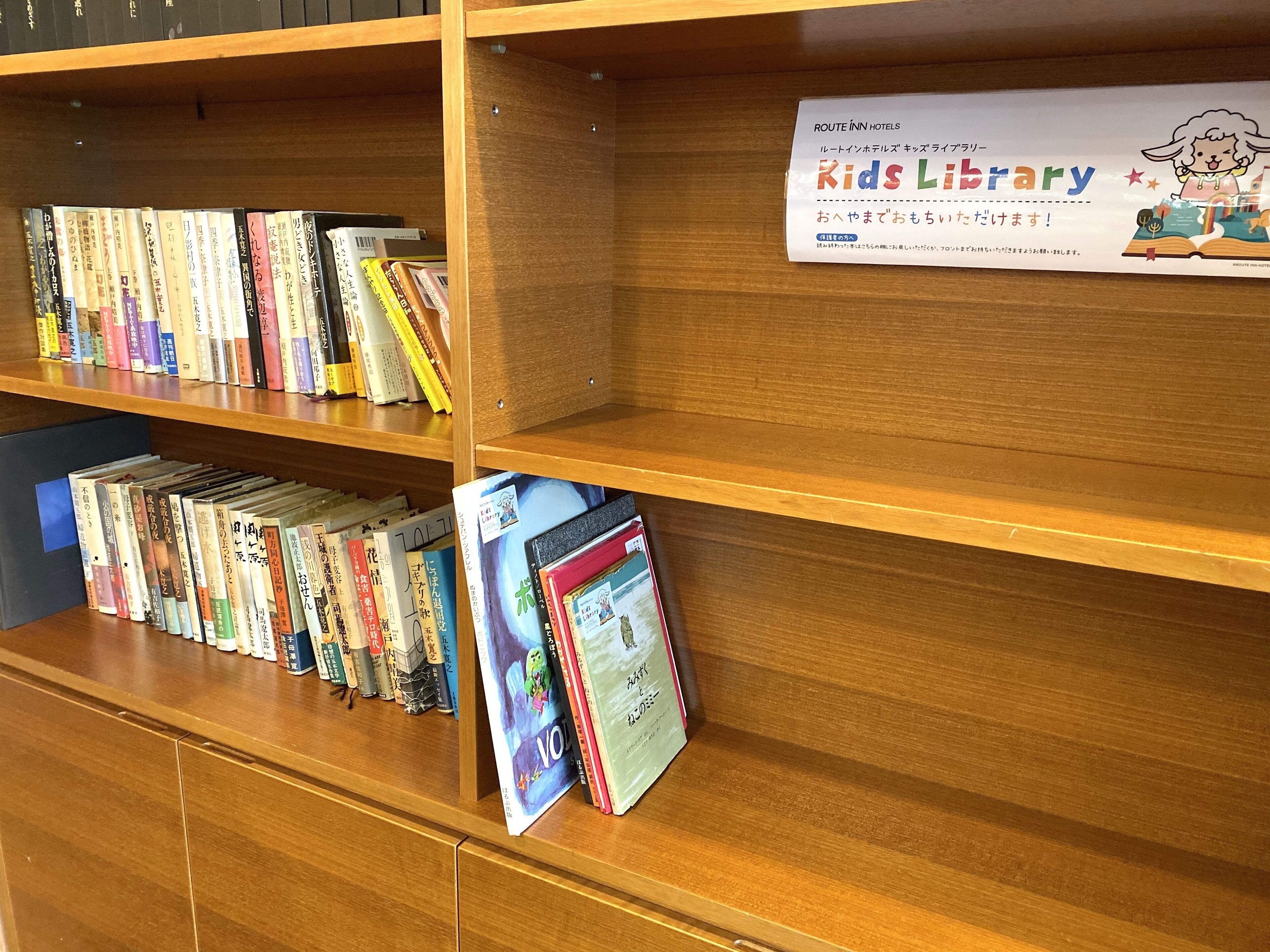 A library section with bookshelves and a sign for the Kids Library.
