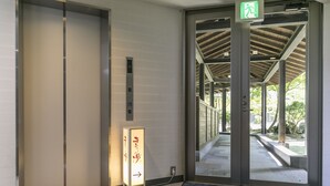 An elevator with a sign indicating the direction to the first floor. - Aso Resort Grandvrio Hotel (Aso)