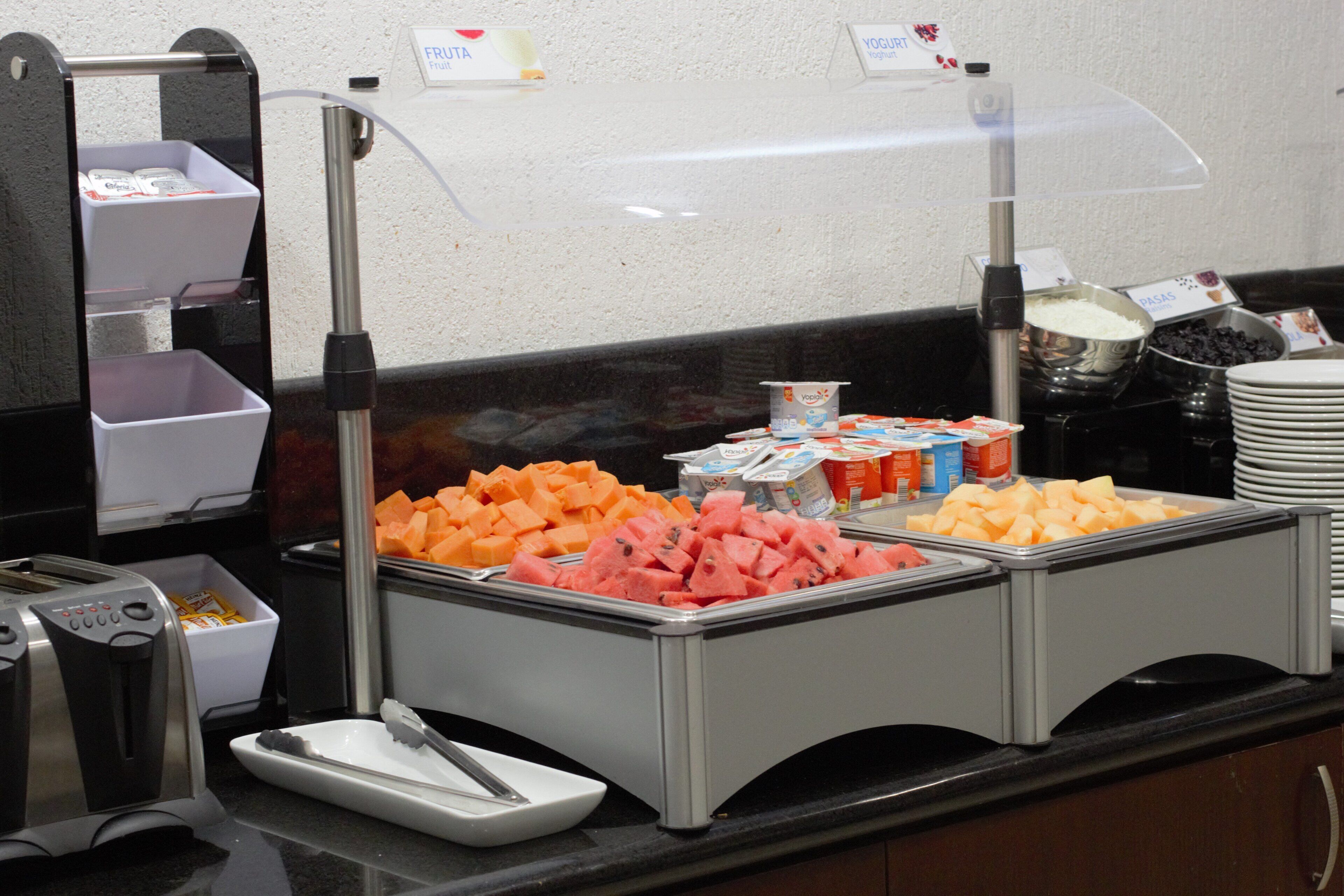 Ein reichhaltiges Buffet mit verschiedenen Speisen, darunter Obst und Milchprodukte.