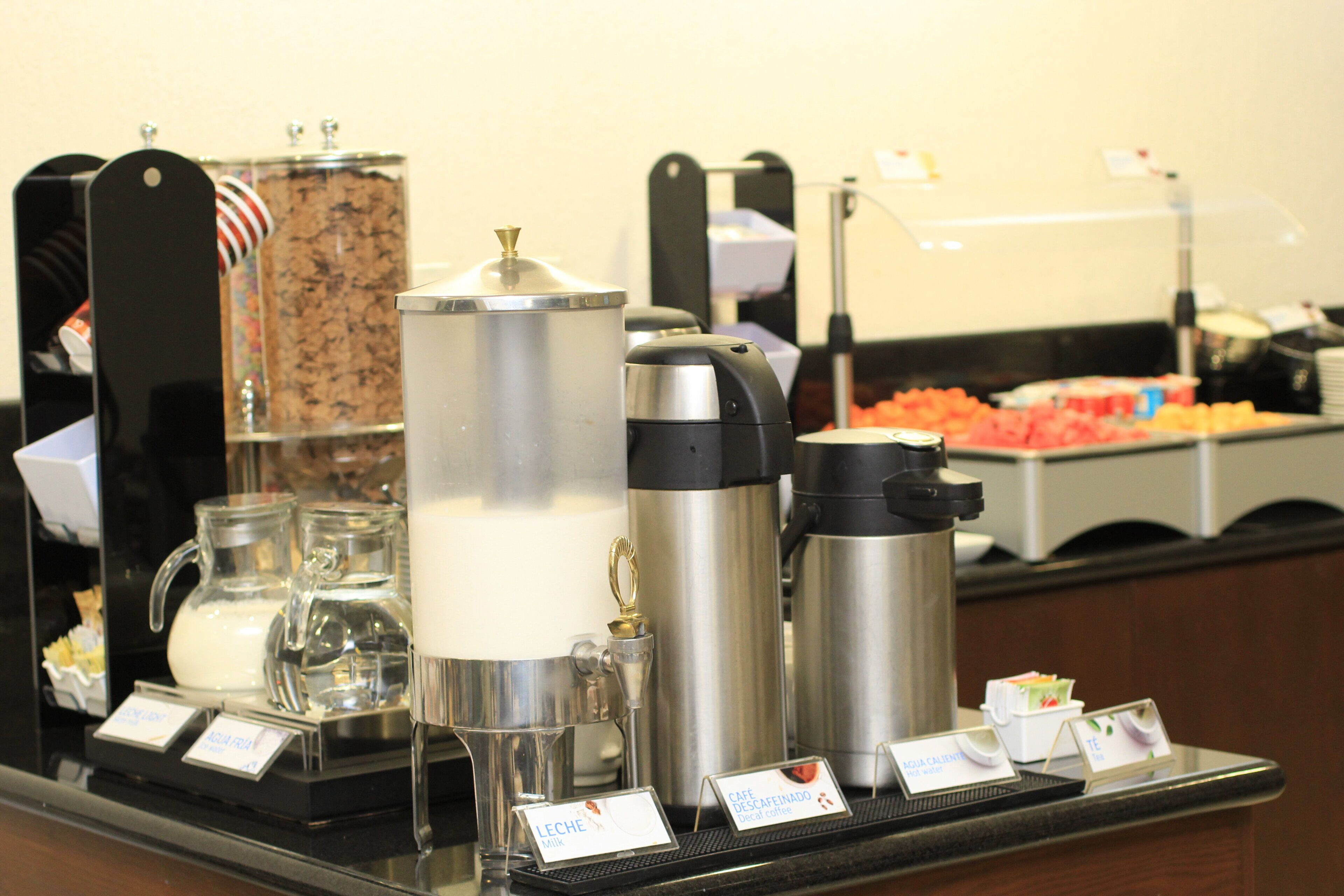 A buffet setup with various food items and beverage dispensers.