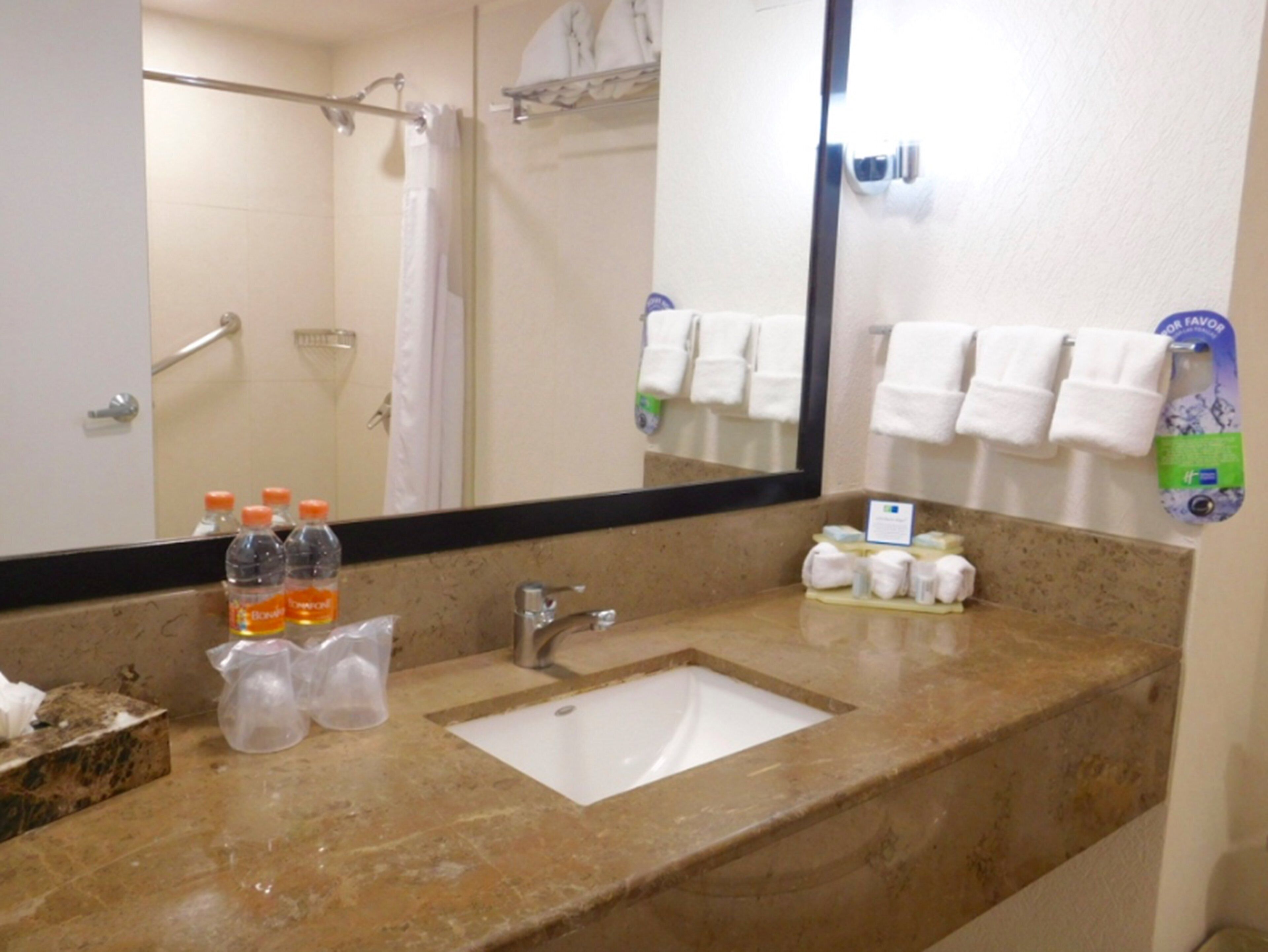 A bathroom with a sink, mirror, and towel rack.