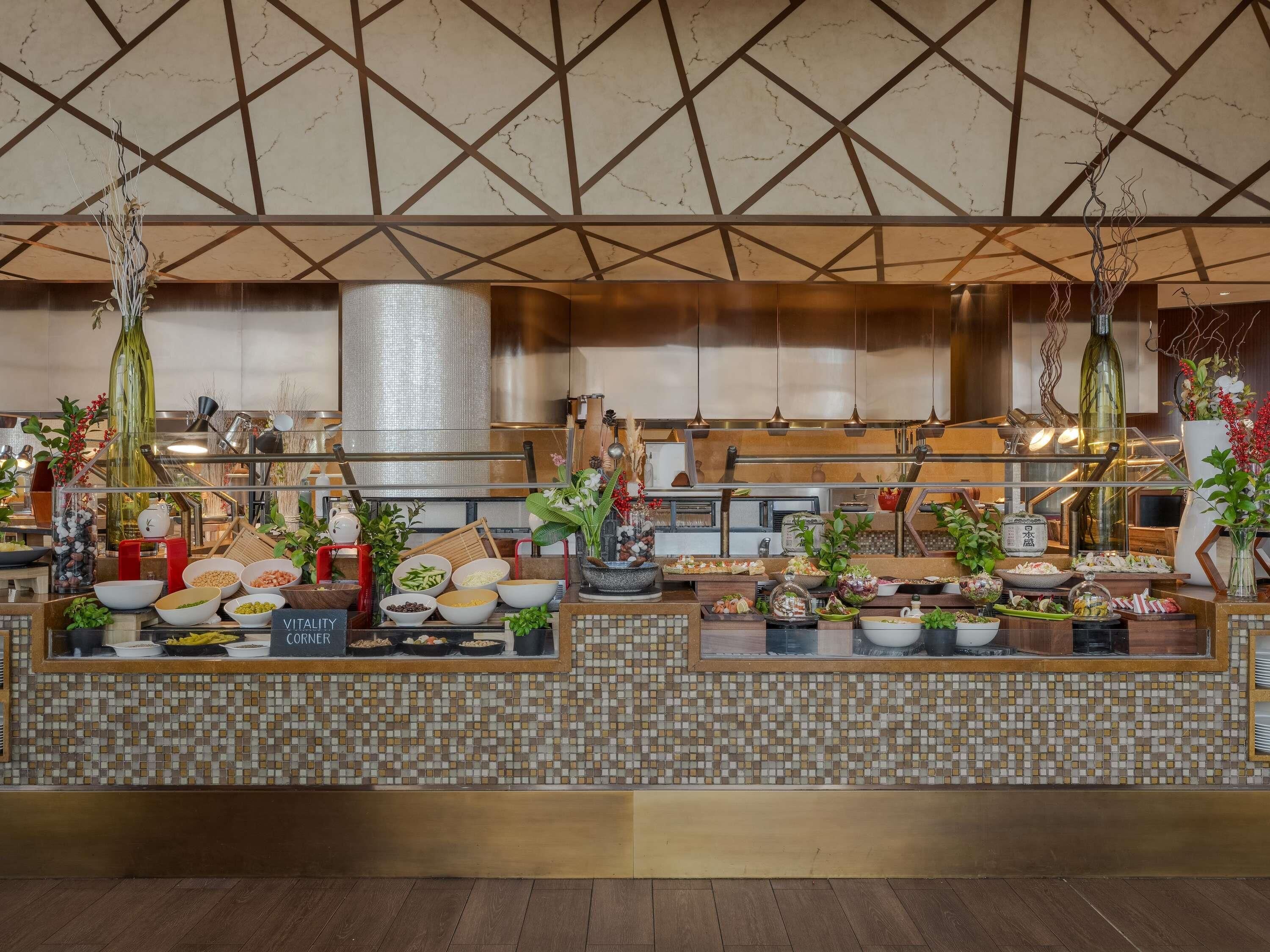A restaurant with a tiled backsplash and a variety of dishes displayed on the counter.