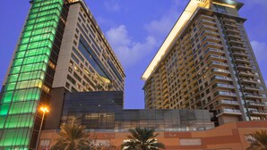 Two high-rise buildings with a modern architectural design, featuring glass facades and balconies.