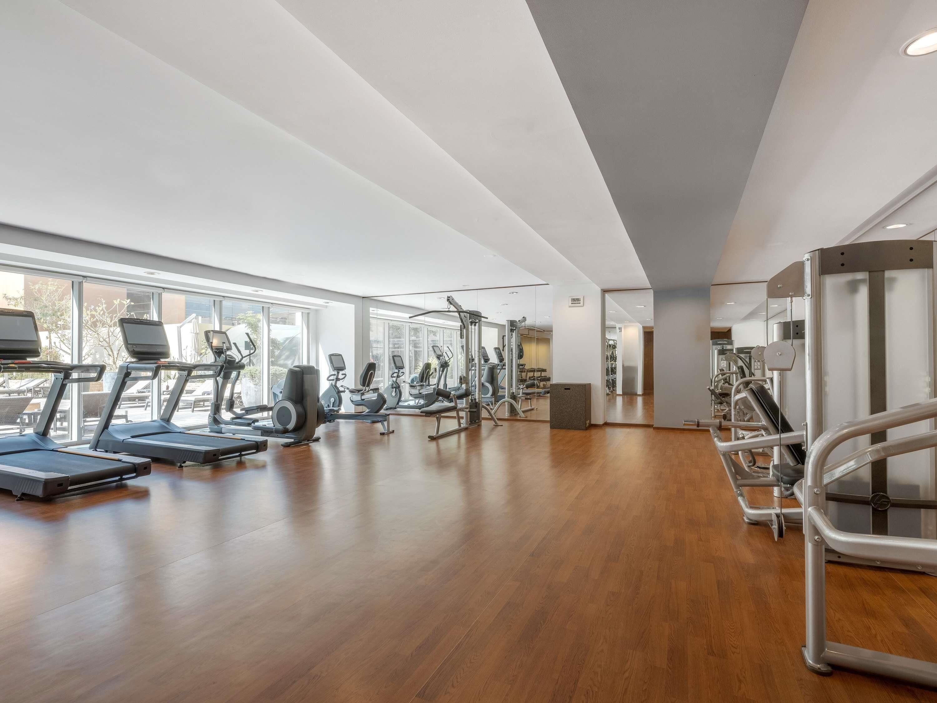 A gym with treadmills, elliptical machines, and weight equipment.