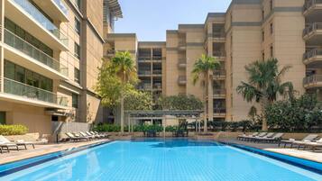 Una piscina al aire libre, una piscina climatizada, sombrillas