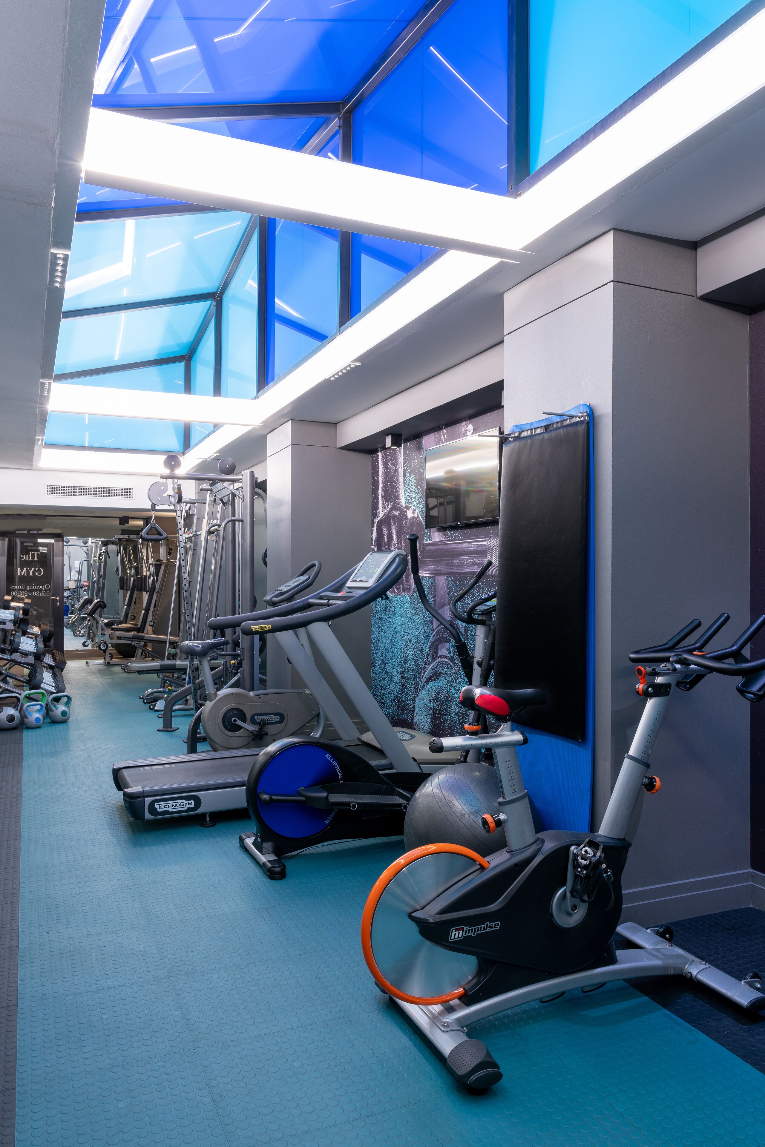 A gym with various exercise equipment, including treadmills, elliptical machines, and weight machines.