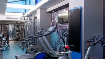 A gym with various exercise equipment, including treadmills, elliptical machines, and weight machines.