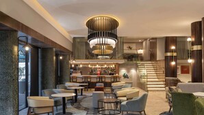 A modern lobby with a central bar, seating areas, and a staircase leading to upper floors. - Radisson Hotel Cape Town Foreshore (Cape Town)