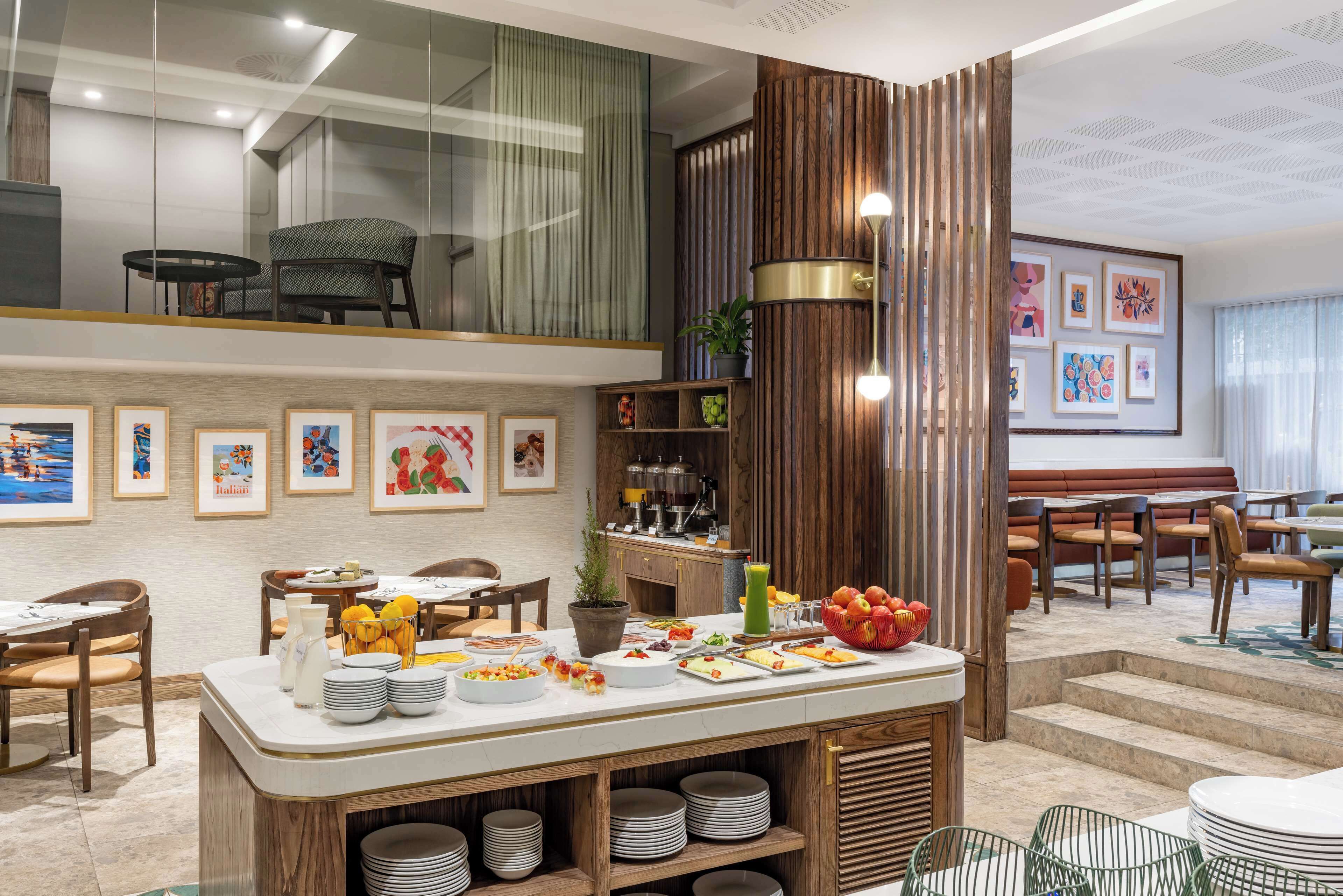 A dining area with a buffet setup, wooden accents, and artwork on the walls.