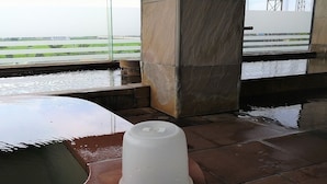 Ein Poolbereich mit Glasverkleidung und Blick auf eine Landebahn und den Flughafen im Hintergrund.