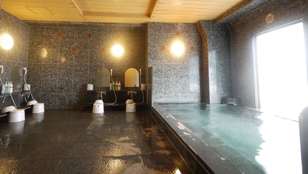 A sauna room with a tiled floor, a bench, and a large window. - Hotel Route-Inn Yokohama Bashamichi (Yokohama)