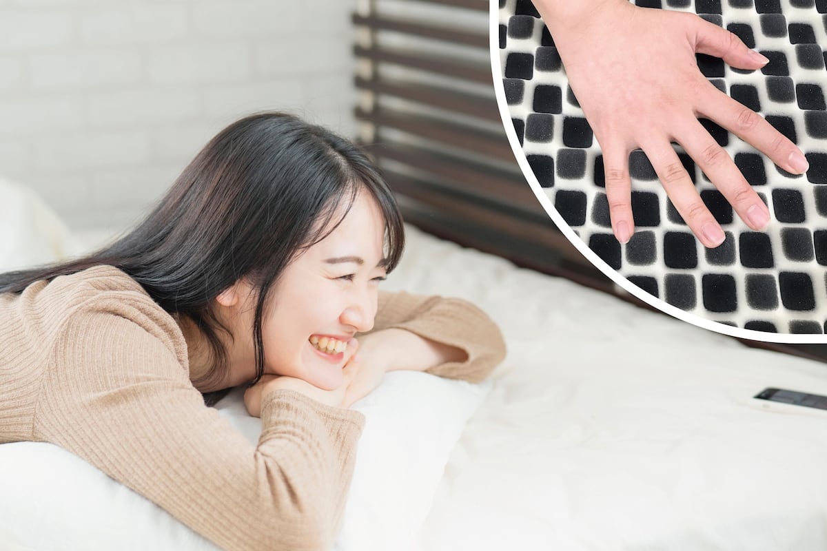 Une personne allongée sur un lit, avec un oreiller et un téléphone intelligent à portée de main.