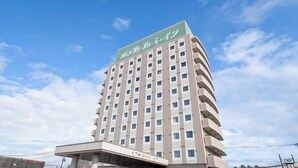 A multi-story hotel with a green sign at the top, a covered entrance, and a clear blue sky in the background. - Hotel Route - Inn Towada (Towada)