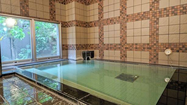 An indoor swimming pool with a tiled wall and a window. - Hotel Route - Inn Towada (Towada)
