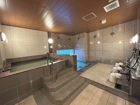 A modern bathroom with a glass-enclosed hot tub, a separate shower area, and a vanity with multiple sinks.