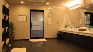 Uma casa de banho moderna com um espelho grande, uma pia e um cesto de lixo.