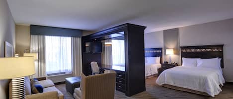 Une chambre d’hôtel équipée d’un lit, d’un bureau, d’une chaise, d’un canapé et d’une télévision.