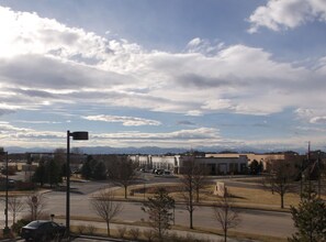 A view of a parking lot with a few cars, surrounded by buildings and trees. - Hampton Inn & Suites- Denver/Airport-Gateway Park (Denver)