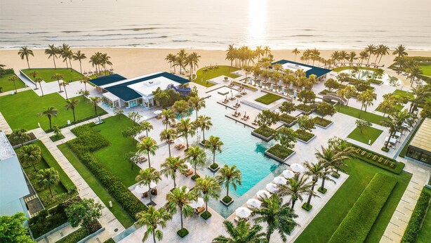 An aerial view of a resort with a central pool, palm trees, and a beach. - Hyatt Regency Danang Resort and Spa (Da Nang)