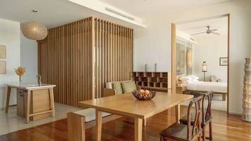 Uma sala de estar moderna com uma mesa de jantar de madeira, cadeiras, um sofá e um painel decorativo na parede.