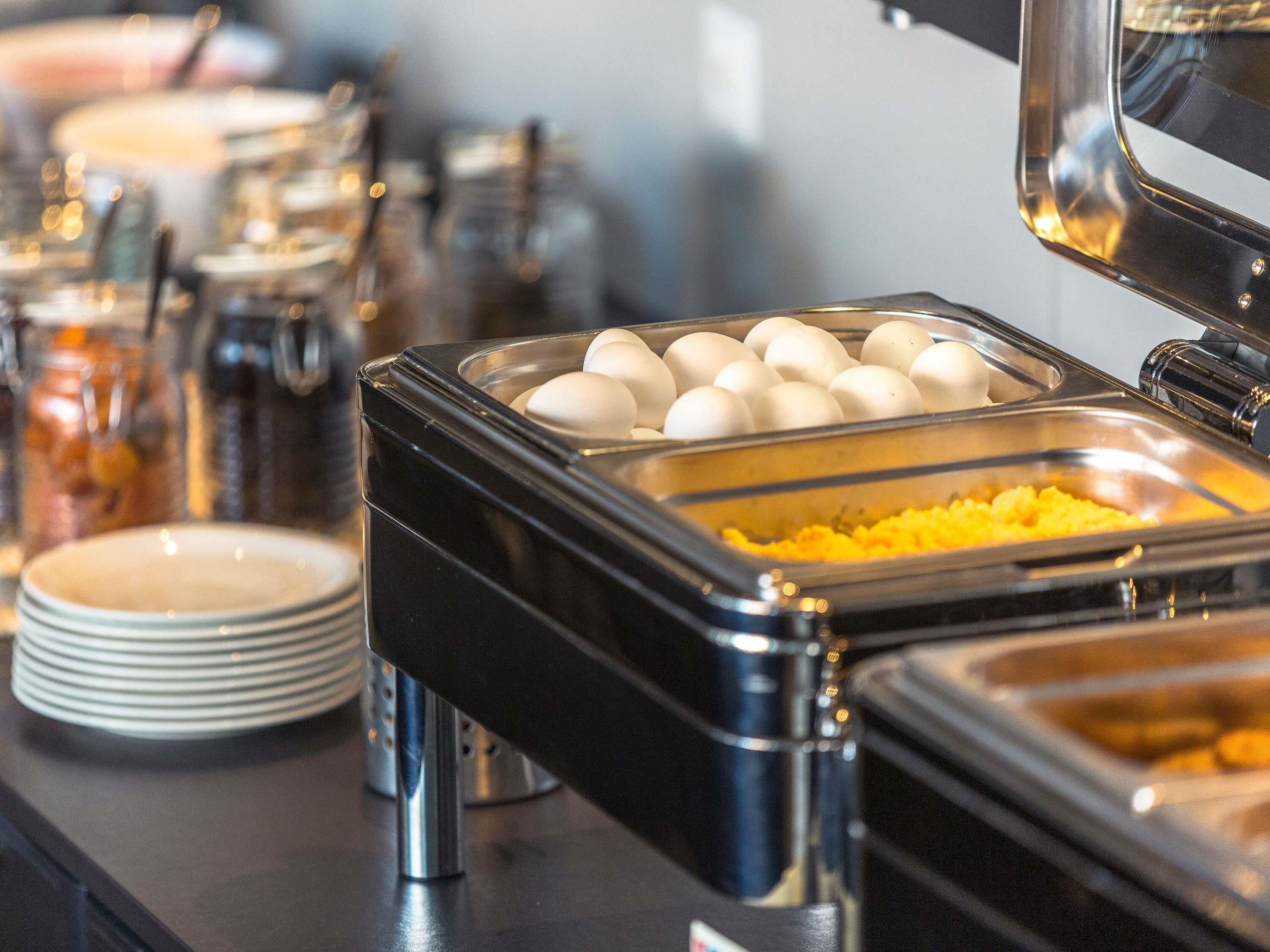 Una mesa de buffet con diversos alimentos y utensilios.