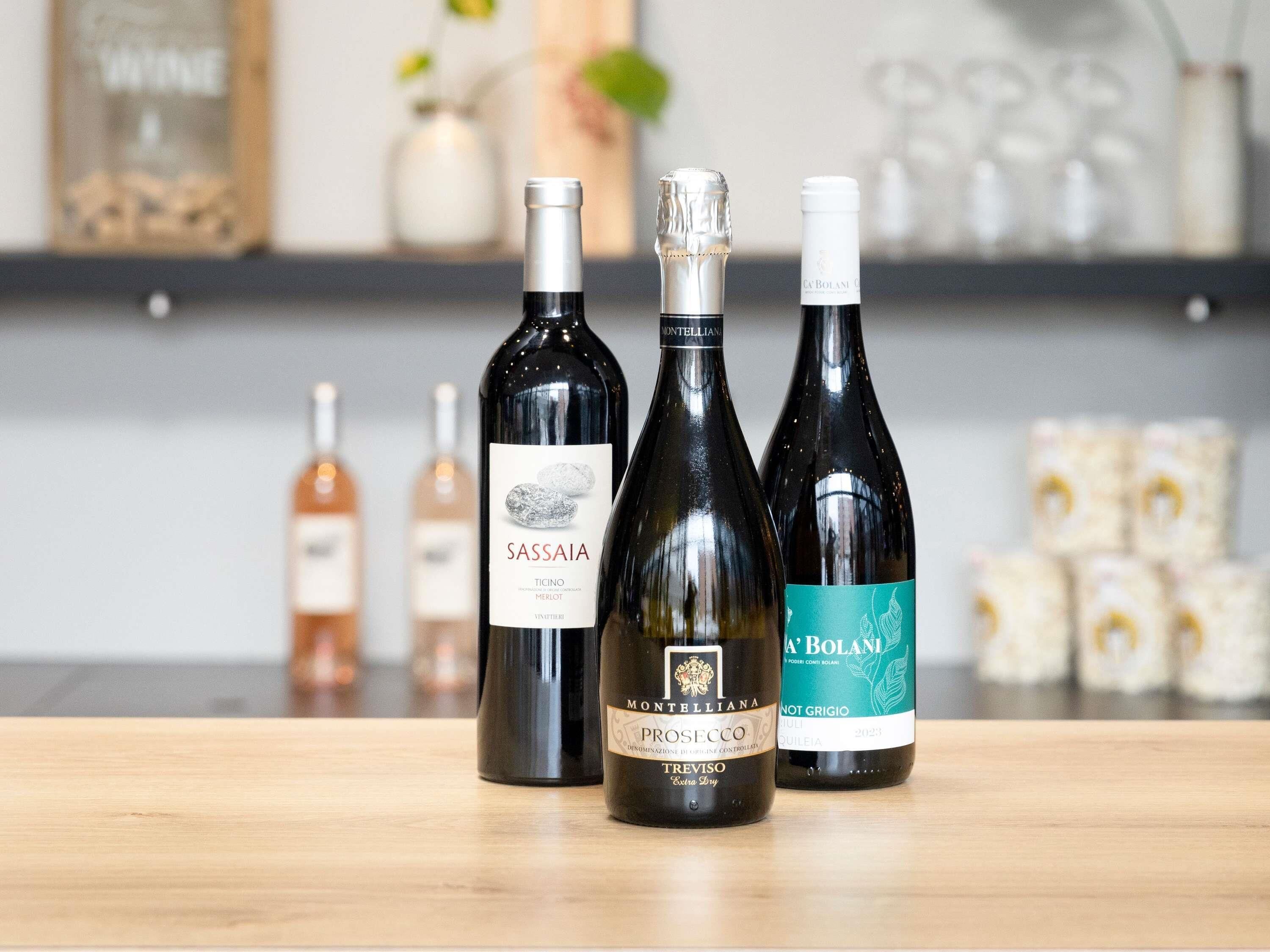 Tres botellas de vino sobre una superficie de madera.