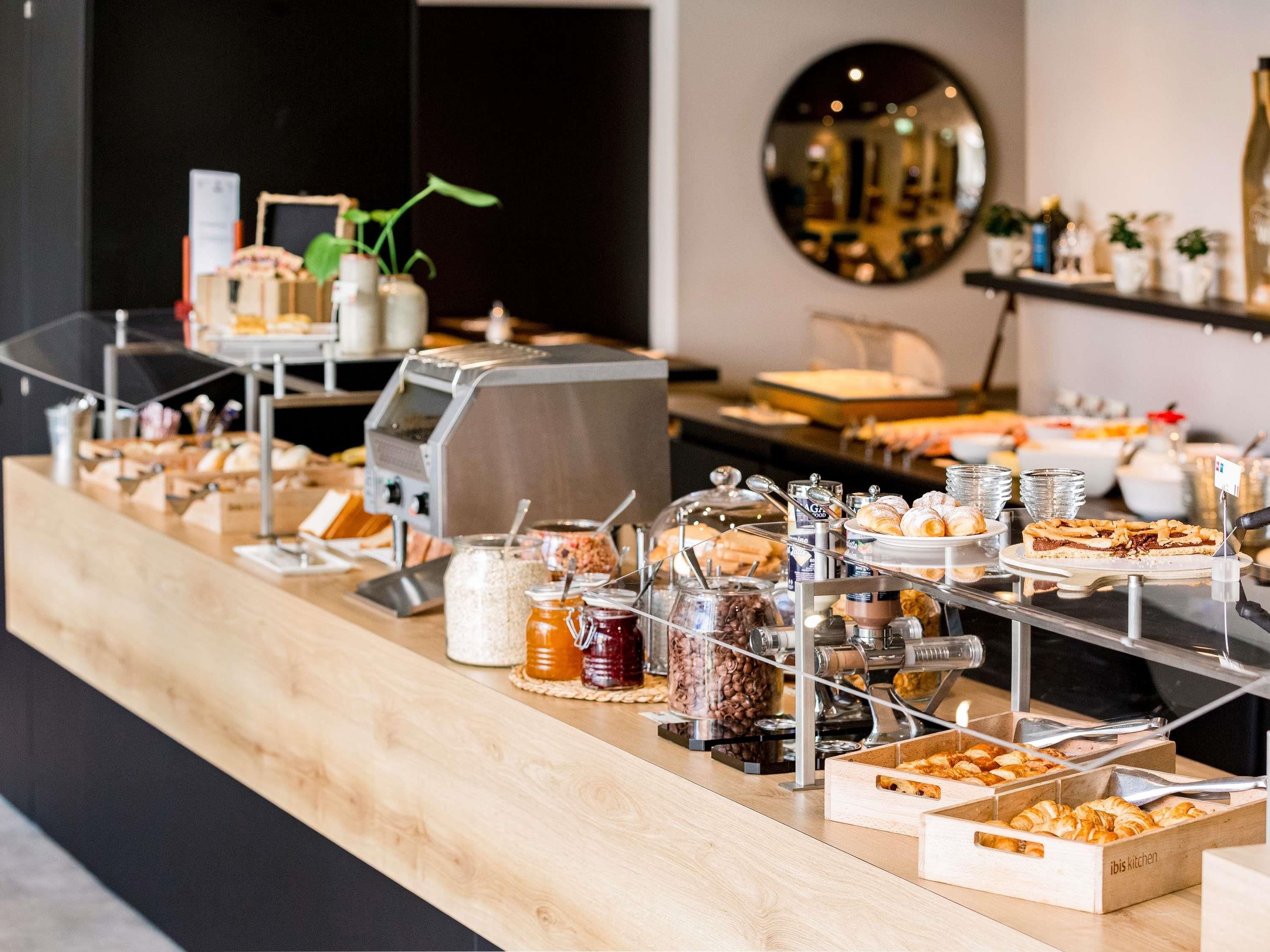 A buffet setup with various food items and condiments.