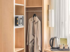 A hotel room with a coat hanging on a rack, a kettle, cups, and a menu on the table. - ibis Lugano Paradiso (Paradiso)