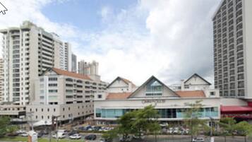 A multi-story hotel with a central atrium, large windows, and a parking lot in front.