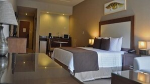 A hotel room with a bed, bedside tables, a desk, and a chair. - Hotel y Casino Central Park Panama (Panama City)