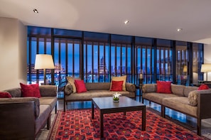 A modern hotel room with a large window, a sofa set, a coffee table, and a patterned rug. - The Westin Xian (Xi'an)