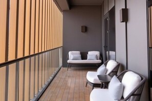 A balcony with a seating area, a small table, and a wall-mounted device. - The Westin Xian (Xi'an)