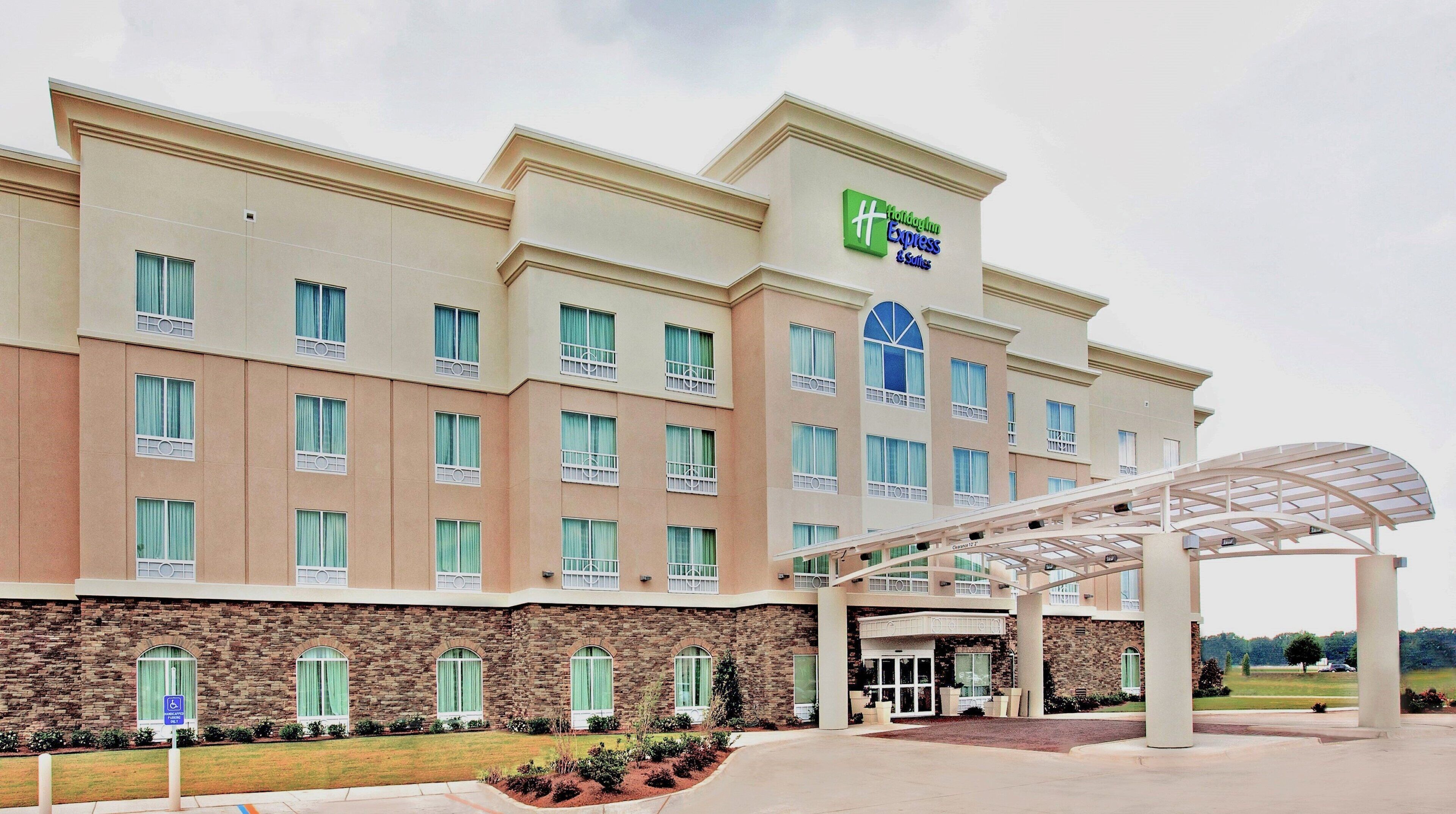 A hotel with a stone facade, multiple windows, and a covered entrance.