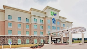 A hotel with a stone facade, multiple windows, and a covered entrance. - Holiday Inn Express Hotel & Suites Bossier City - Louisiana by IHG (Bossier City)
