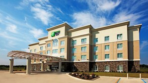 A hotel with a covered entrance, multiple balconies, and a clear sky. - Holiday Inn Express Hotel & Suites Bossier City - Louisiana by IHG (Bossier City)