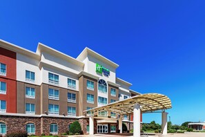 Un hôtel à plusieurs étages, reconnaissable à son grand panneau vert indiquant qu’il s’agit d’un hôtel de la chaîne Wyndham Express.