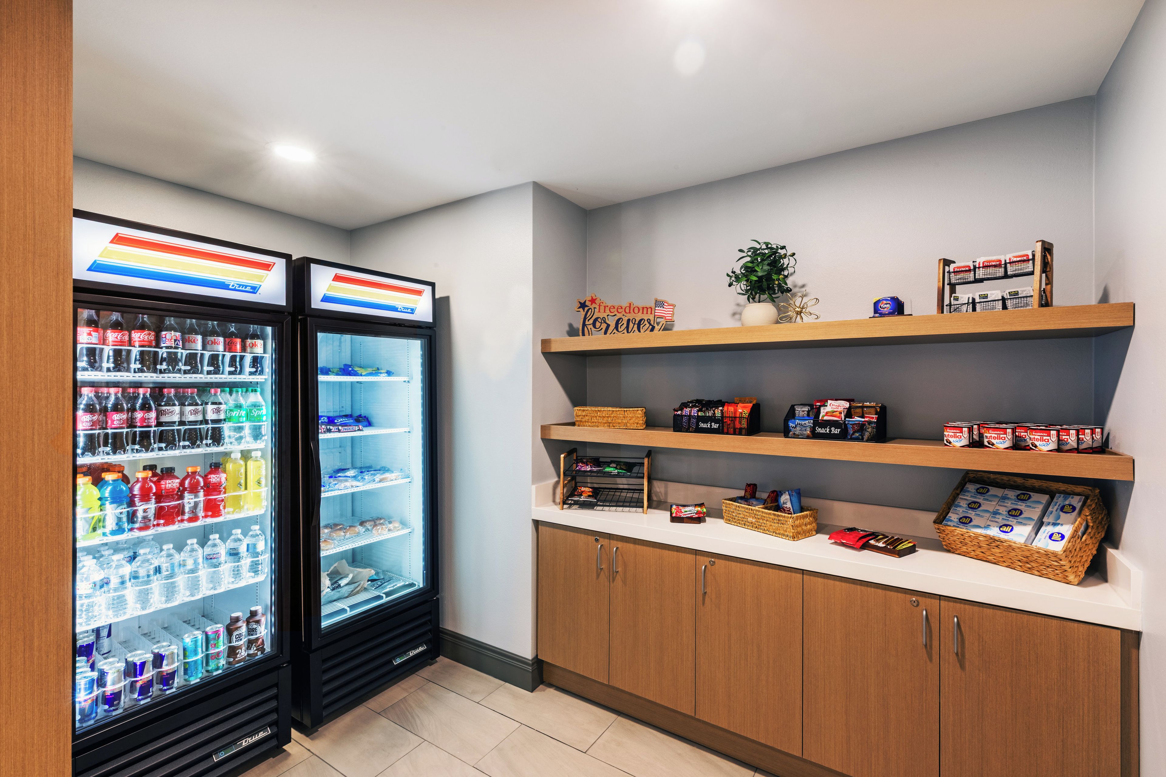 Ein Verkaufsautomatenbereich mit zwei Kühlschränken, gefüllt mit Getränken und Müsliriegeln.