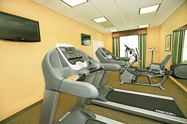 A fitness room with treadmills, an elliptical, and a stationary bike.
