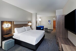A hotel room with a bed, bedside tables, a desk, a chair, a TV, and a wall-mounted artwork. - Holiday Inn Express Hotel & Suites Bossier City - Louisiana by IHG (Bossier City)