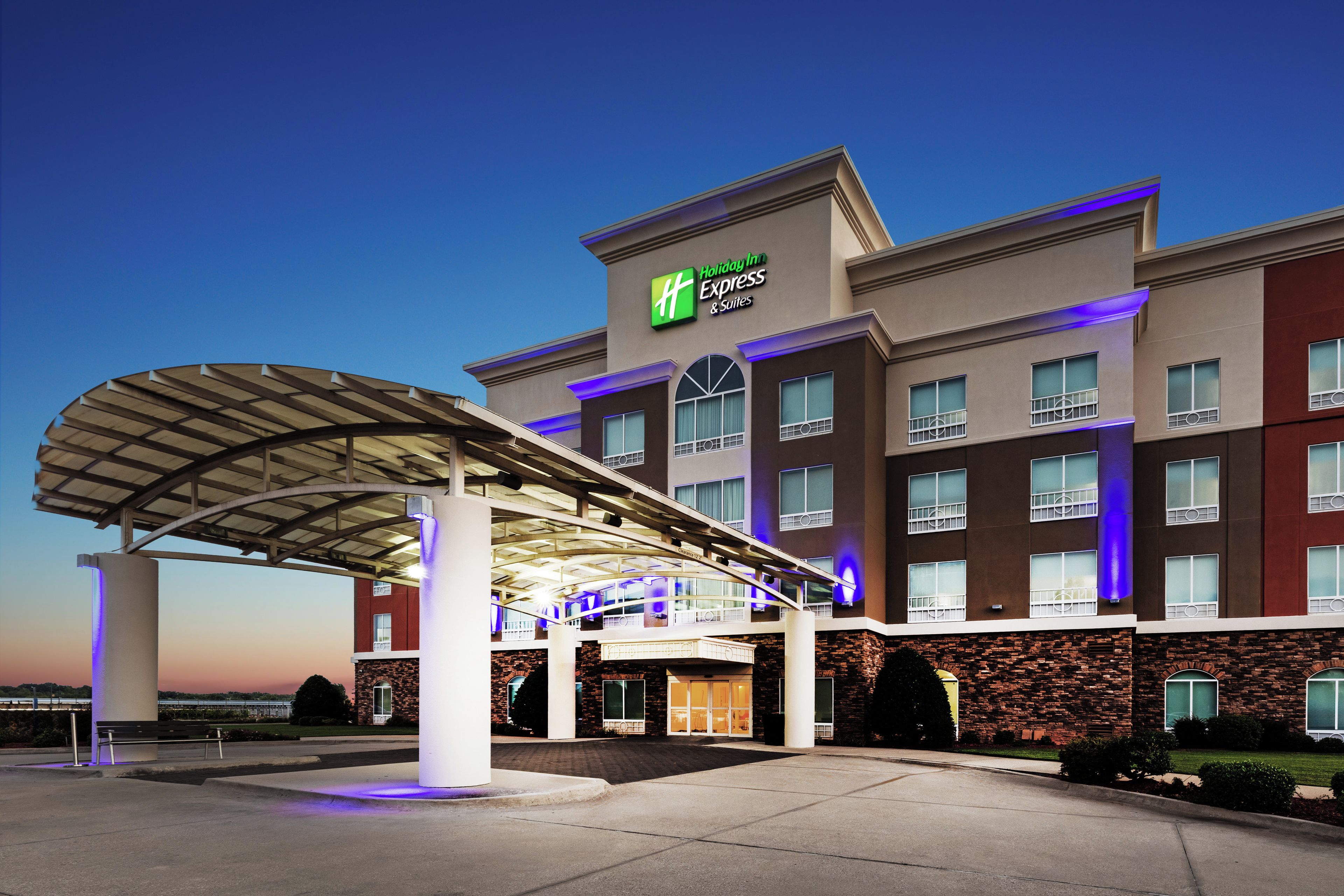 A Holiday Inn Express & Suites building with a covered entrance and multiple windows.