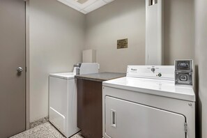 A laundry room with a Whirlpool washer and dryer, a sign indicating laundry products are available at sundry area, and a price tag of $3.00. - Best Western Plus Brandon Inn (Brandon)