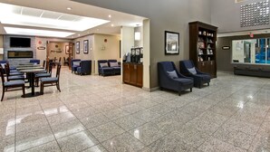 A spacious lobby with a reception desk, seating area, and a large bookshelf. - Best Western Plus Brandon Inn (Brandon)