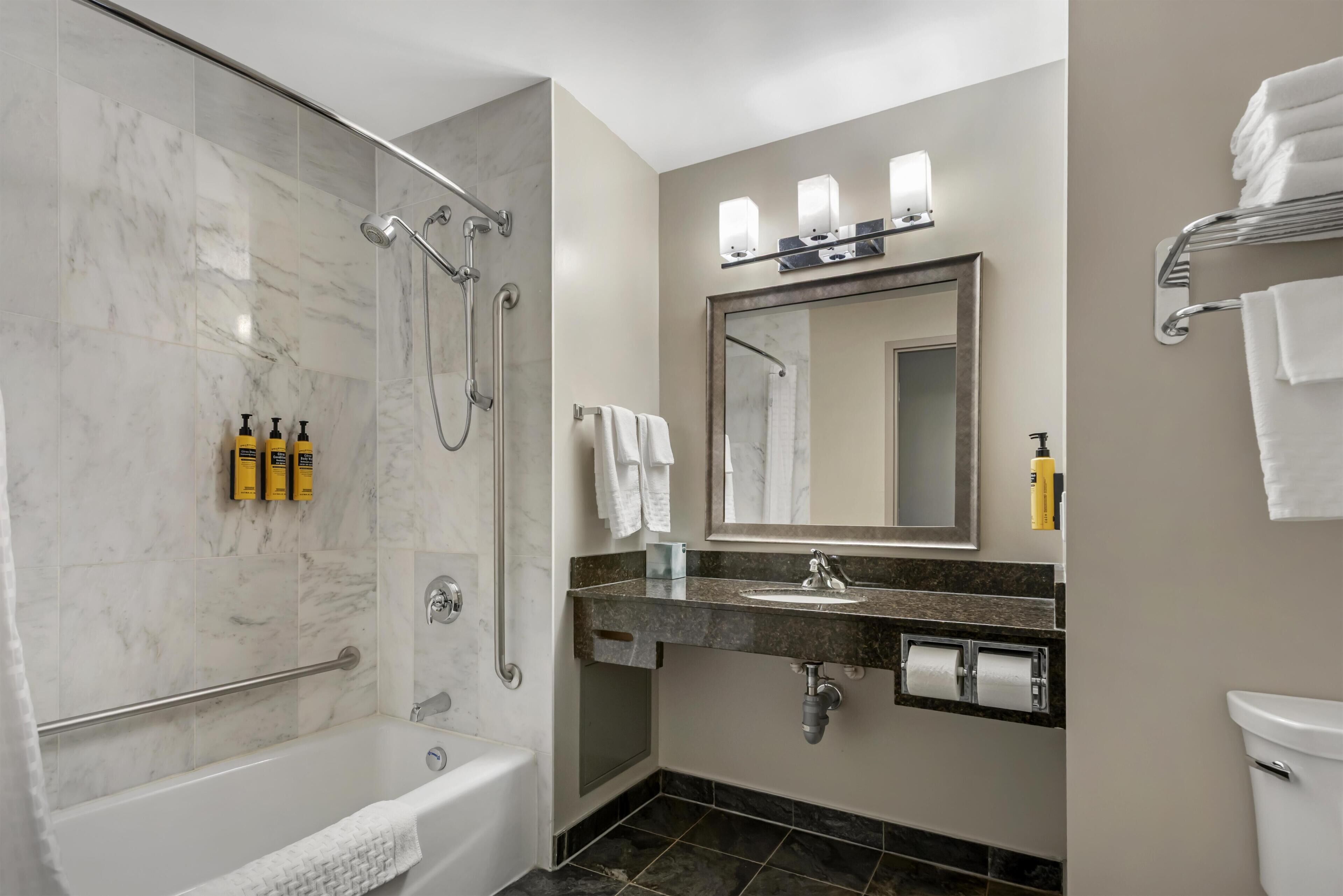 A modern bathroom with a walk-in shower, a bathtub, a vanity with a sink, and a toilet.