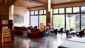 En rummelig lobby med siddeområder, store vinduer og et moderne loftdesign.