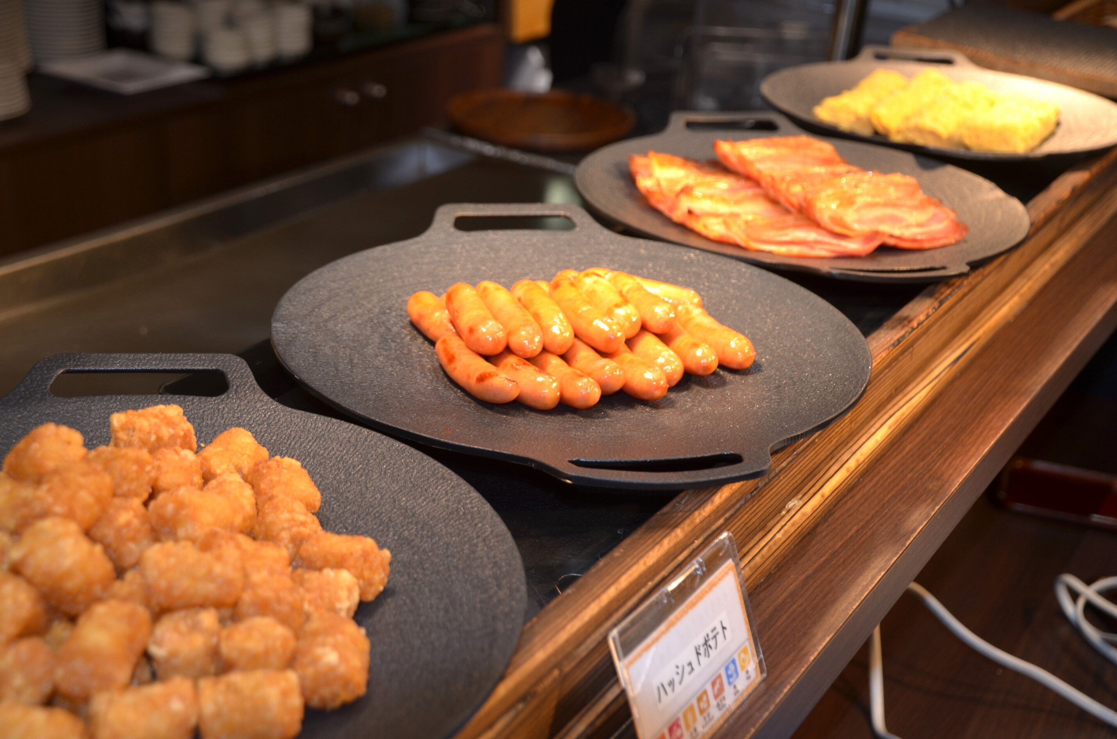 A buffet with various food items including tater tots and omelets.
