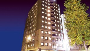 A multi-story hotel with illuminated windows and a sign at the top.