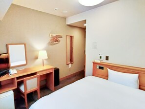 A hotel room with a bed, a desk with a lamp, a mirror, a coat rack, and a small cabinet. - Hotel Route-Inn Aomori Ekimae (Aomori)