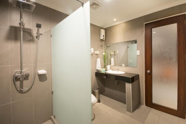 Un baño moderno con ducha, inodoro y lavamanos.